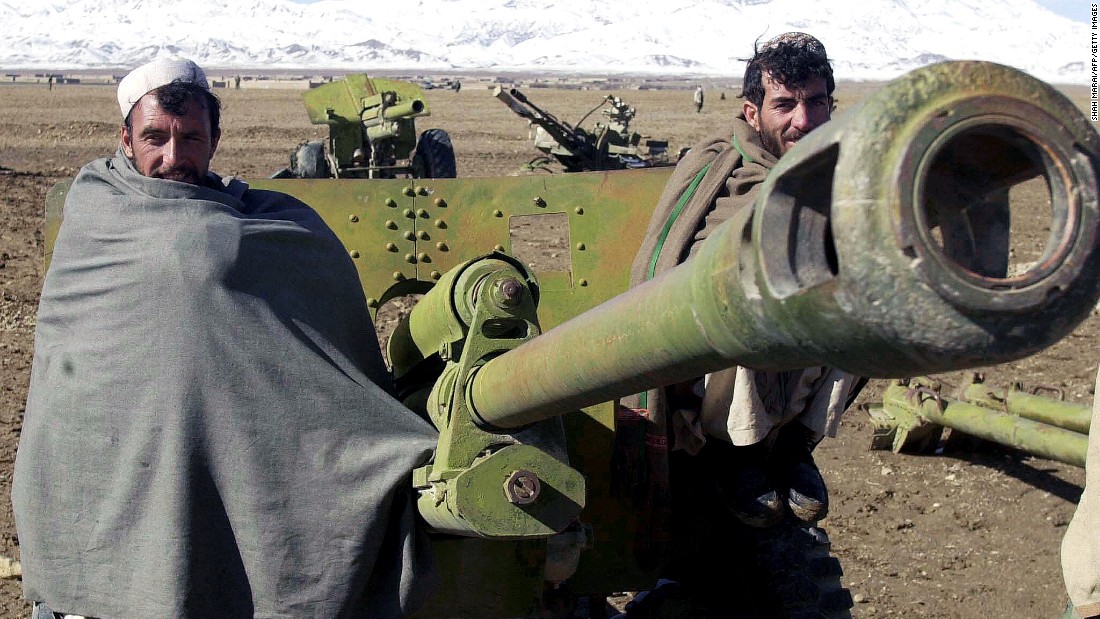 Afghan militiamen pose in front of a 80mm rocket launcher during a disarmament cermony in Gardez the capital of Paktia province November 2003