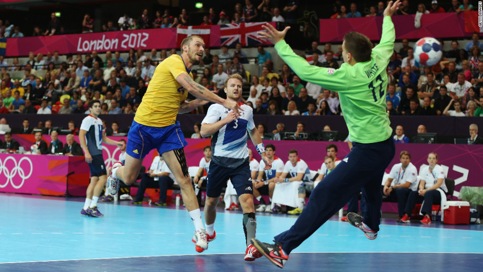 Sweden's Fredrik Petersen scores on Robert White of Great Britain during the men's handball preliminary match between Britain and Sweden on Tuesday.