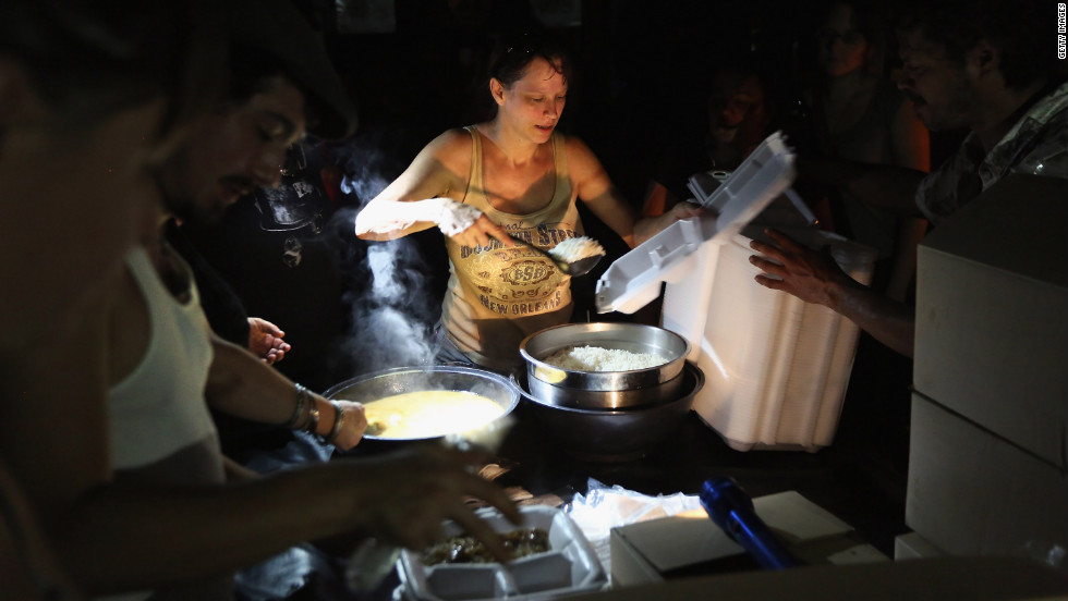Local residents serve up chicken etouffee and rice delivered by the Louisiana National Guard at JJ's Bar in the Bywater neighborhood of New Orleans. The military gave out the food to residents of the area, which was still without electricity three days after Hurricane Isaac knocked out power to hundreds of thousands of people.