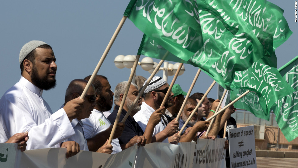 Arab-Israeli men wave green Islamic flags with the Muslim profession of belief: "There is no God but God and Mohammed is the prophet of God" during a protest in front of the U.S. Embassy on Thursday in Tel Aviv, Israel.