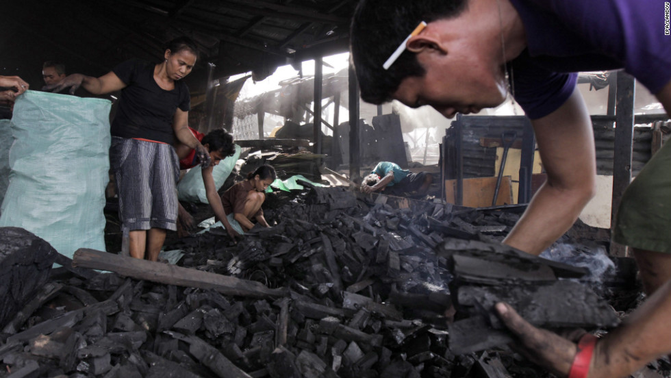 Residents of the slum of Tondo in Manila, Philippines, make charcoal by burning wood in shallow pits on Monday, October 22. Recent studies show that air pollution in Manila causes 60% of lung cancer cases, costing the country about $1.2 million in reduced productivity and another $21 million in health care.