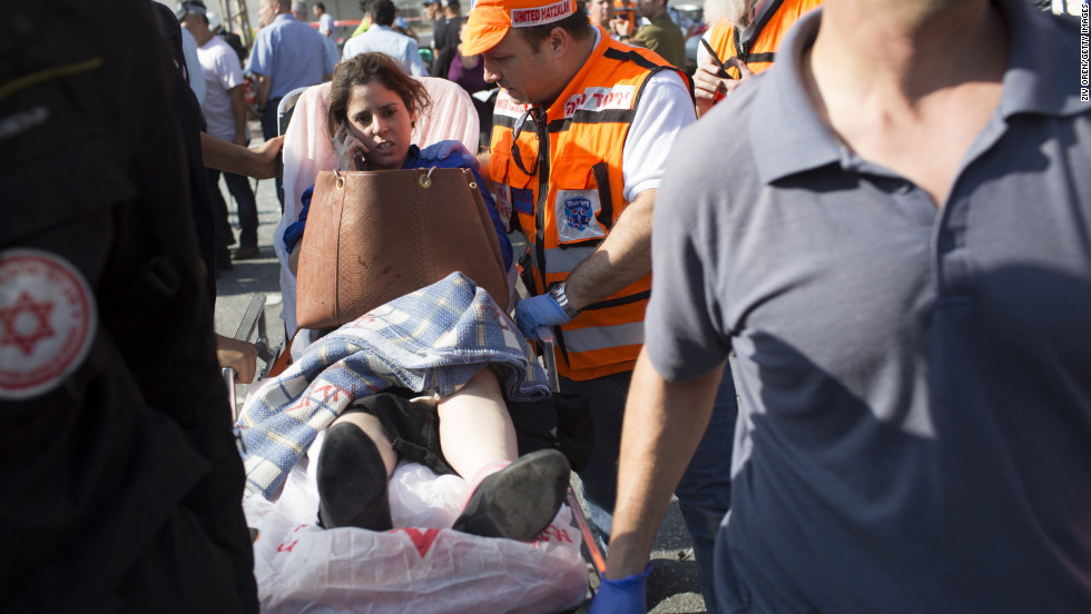 A woman is helped at the scene by emergency workers Wednesday after the explosion on the bus in Tel Aviv.