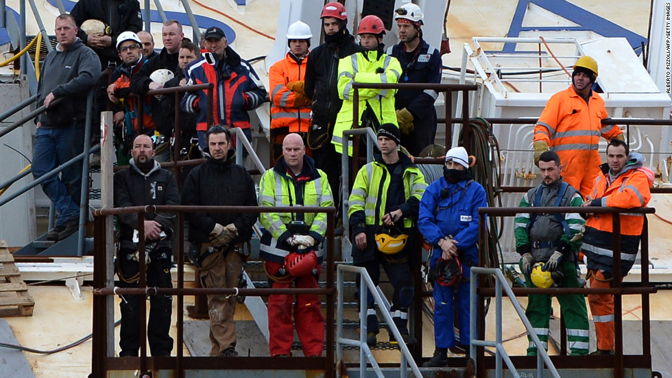 Workers stand on the wrecked Costa Concordia cruise ship off the Italian island of Giglio on Sunday, January 13, during commemorations marking the first anniversary of the cruise liner disaster. Survivors, grieving relatives and locals on the island of Giglio gathered to remember the 32 people who were lost.
