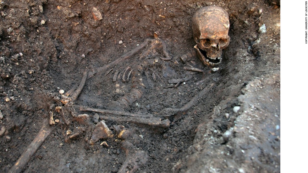 The skeleton being excavated, showing the curve in the spine and the way the head had been squashed into the grave. The hands may have been tied.