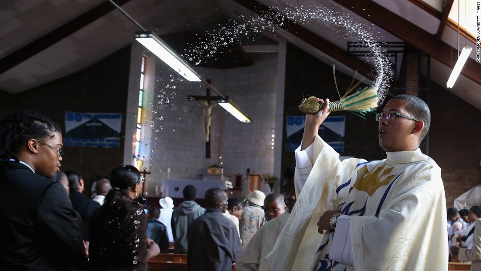The Rev. Sebastian Rossouw O.M.I. sprinkes holy water on congregants during Easter services at Regina Mundi Catholic Church in the Soweto area of Johannesburg, South Africa, on Sunday, March 31.