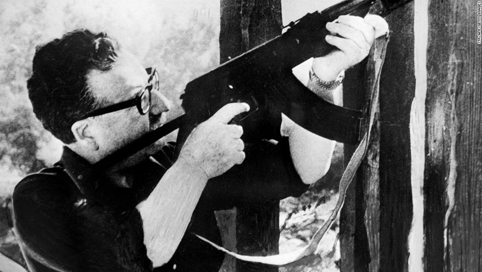This picture taken circa 1971 in Santiago, shows Chilean President Salvador Allende testing a Kalashnikov machine gun given to him as a gift by the then-Cuban President Fidel Castro.
