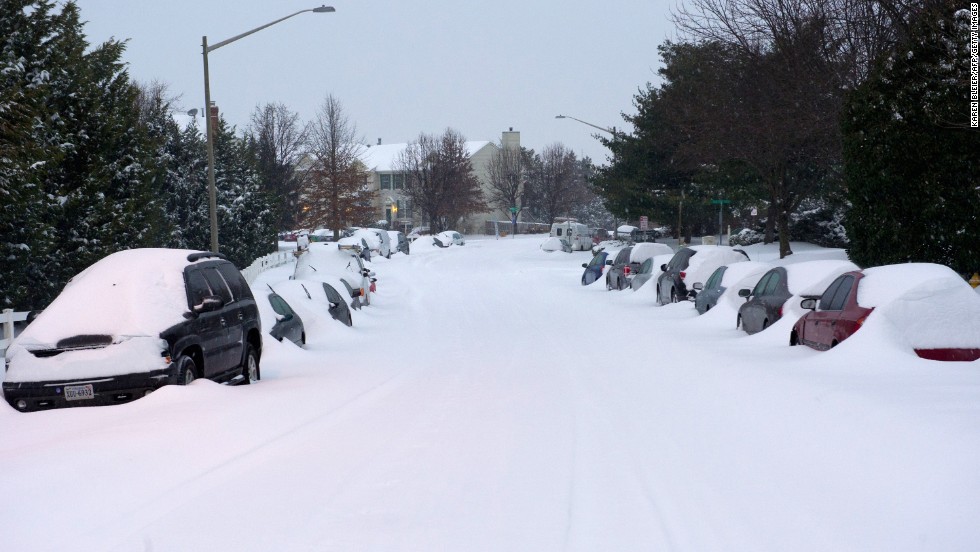 Cars sit covered in snow on a street in Manassas, Virginia, on February 13.