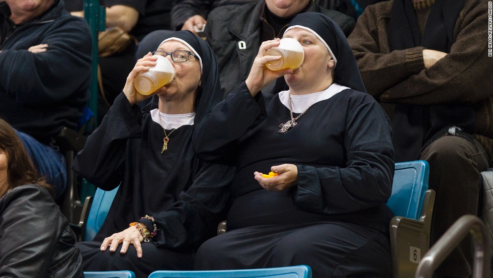 Two women wearing nun outfits drink beer while they watch curling Saturday, March 8, in Kamloops, British Columbia.