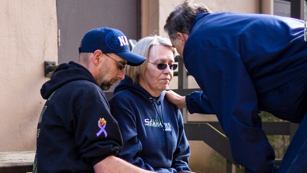 Gov. Jay Inslee, right, comforts Barbara Welsh after a news conference March 23 outside the Arlington Police Department. Welsh's husband, Bill, was among the scores of people listed as missing immediately after the disaster.