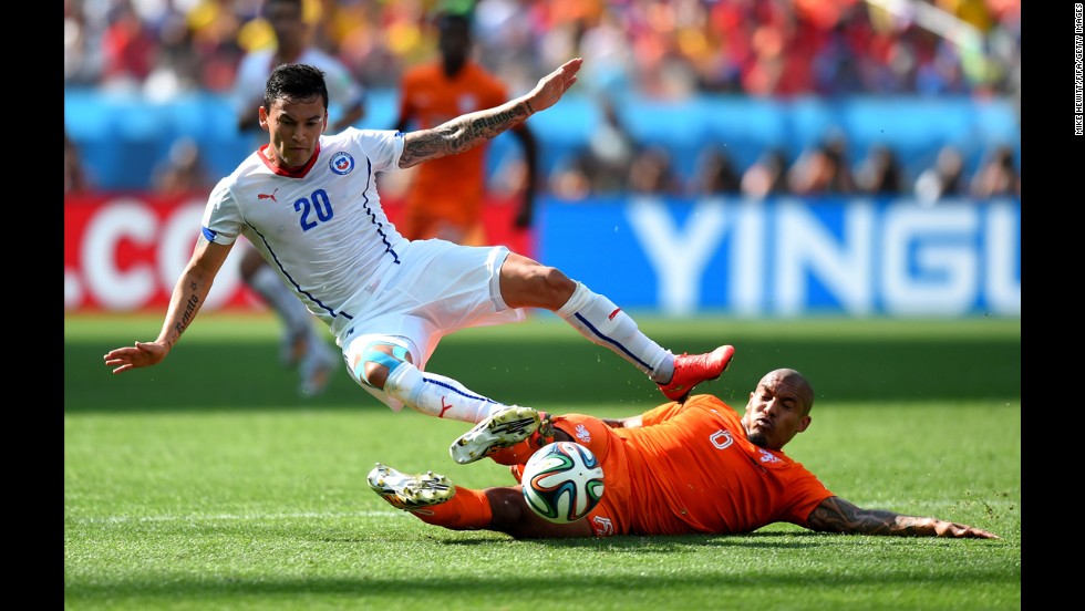 Charles Aranguiz of Chile is tackled by Nigel de Jong of the Netherlands.