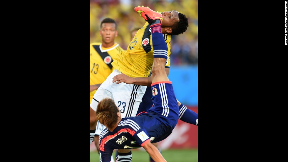 Japan's Yoshito Okubo, bottom, and Colombia's Carlos Valdes vie for the ball.