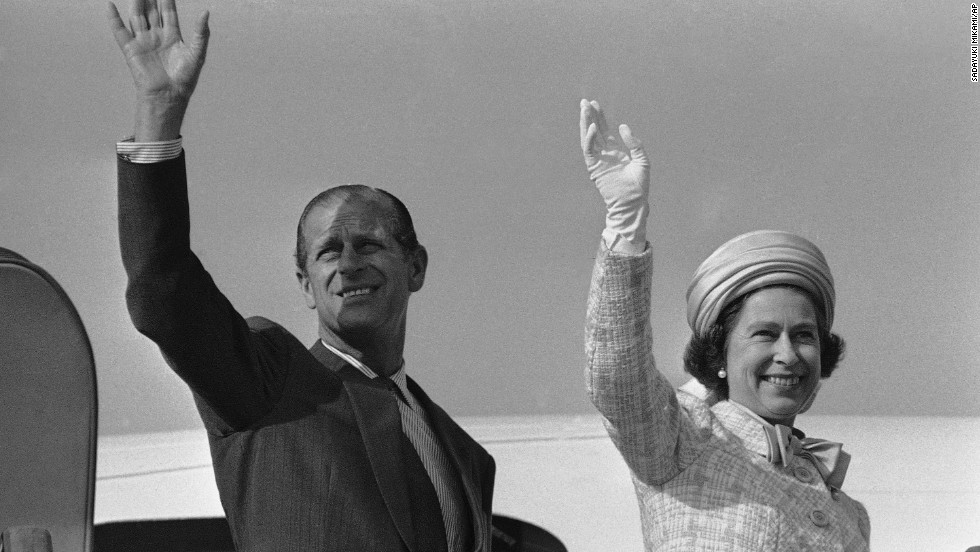 Queen Elizabeth II and Prince Philip wave from a plane ramp shortly before taking off from Tokyo in May 1975.