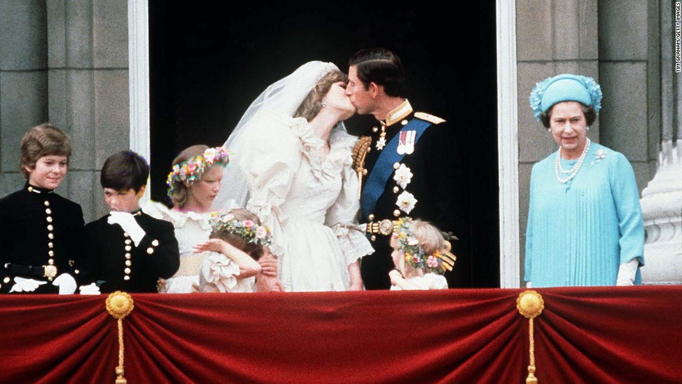 The Queen stands next to Prince Charles as he kisses his new bride, Princess Diana, on their wedding day July 29, 1981.
