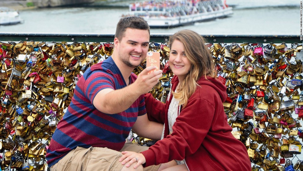 A couple takes a selfie at the Pont des Arts bridge in Paris on Monday, August 11. The bridge sits over the Seine River and offers a fantastic view of the Paris skyline. It is also known for the <a href="http://www.cnn.com/2014/03/31/travel/paris-love-locks/">love locks</a> that people leave on its fence. Couples will often write their initials or names on the locks, attach them to the bridge and then throw the keys overboard to symbolize forever love.