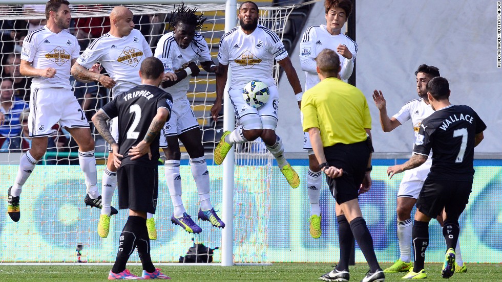 Swansea City's Ashley Williams, center, stops a free-kick taken by Burnley's Ross Wallace during a English Premier League soccer match at Liberty Stadium in Swansea, Wales, on Saturday, August 23. Swansea City won 1-0.