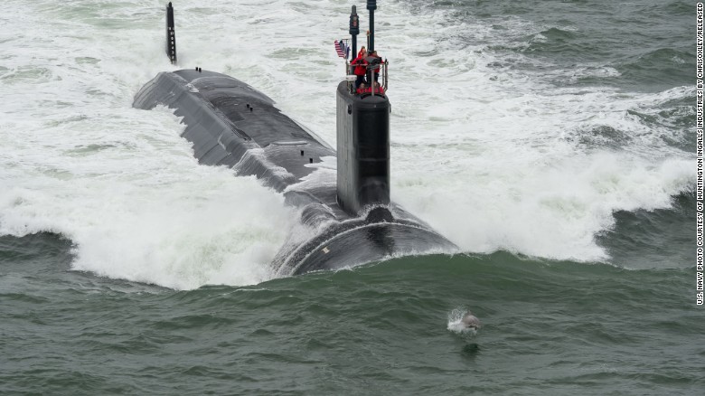 A dolphin swims in front of the Virginia-class attack submarine USS John Warner during its sea trials in May 2015. Virginia-class subs, displacing 7,800 tons and at 377 feet long, &quot;are designed to seek and destroy enemy submarines and surface ships; project power ashore with Tomahawk cruise missiles and special operation forces (SOF); carry out inntelligence, surveillance, and reconnaissance (ISR) missions; support battle group operations; and engage in mine warfare,&quot; according to the Navy.