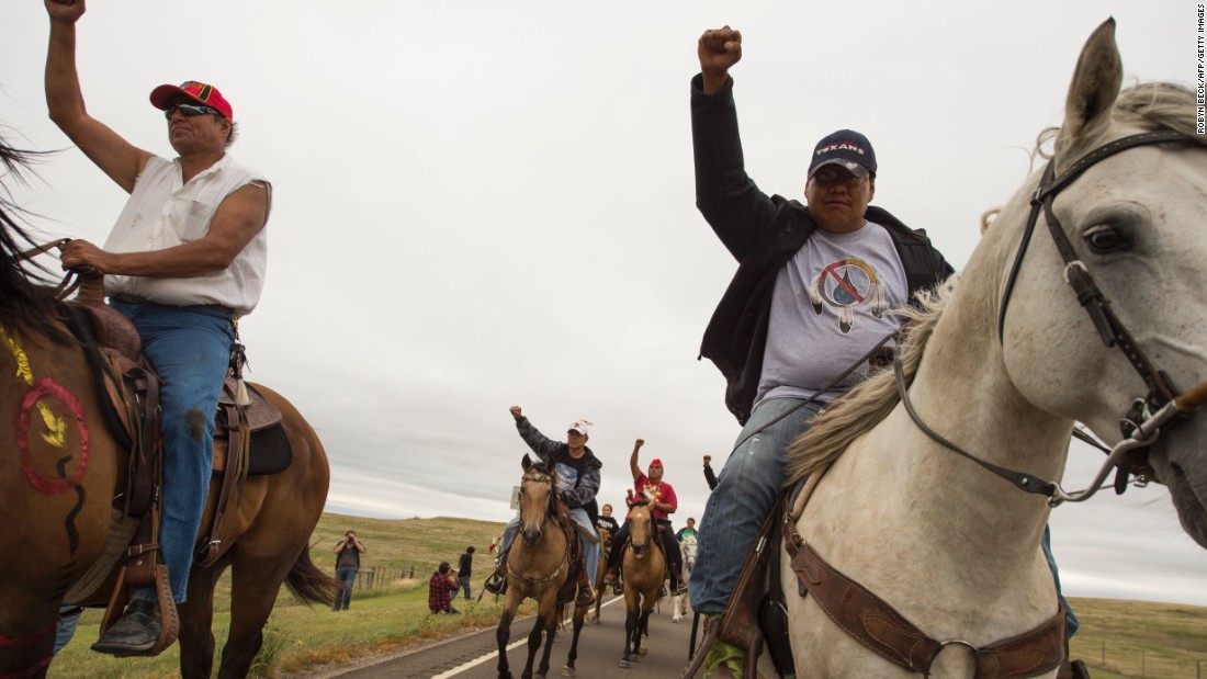Native Americans ride with raised fists to the sacred burial ground on September 4.