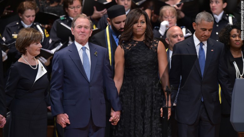 The Bushes and the Obamas join hands during the singing of &quot;The Battle Hymn of the Republic&quot; during an interfaith memorial service for the victims of the Dallas police shooting on July 12, 2016, in Dallas.
