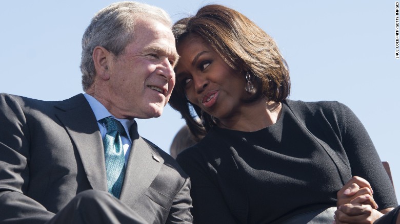 Former President George W. Bush speaks with first lady Michelle Obama during an event marking the 50th anniversary of the Selma to Montgomery civil rights marches at the Edmund Pettus Bridge in Selma, Alabama, on March 7, 2015. 