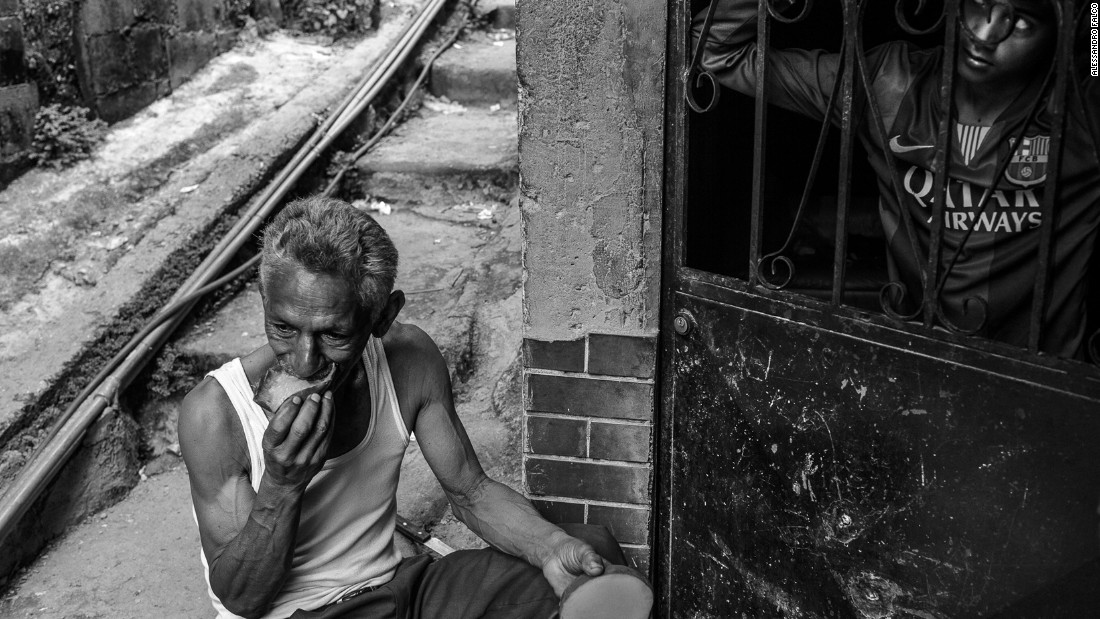 A man eats a mango for lunch in front of his shack in Petare, the largest slum in Caracas.