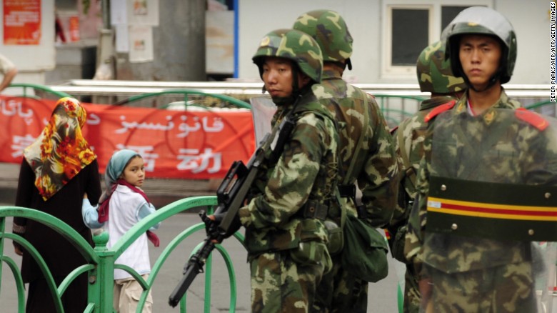 Chinese paramilitary policemen stand guard on a street in the Uyghur district of Urumqi city, Xinjiang, in July 2009.
