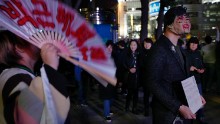 A protester wearing a mask of Park Geun-Hye holds a placard saying "Why do you need Halloween fest? We can see all the horror in our lives," during the protest.