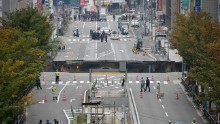 This photo shows a giant sinkhole (C) in a five-lane urban boulevard, eroding soil and exposing underground steel columns supporting commercial buildings in Fukuoka, southwestern Japan, on November 8, 2016. No injuries were reported as the accident occurred in the early morning hours. / AFP / JIJI PRESS / STR / Japan OUT (Photo credit should read STR/AFP/Getty Images)