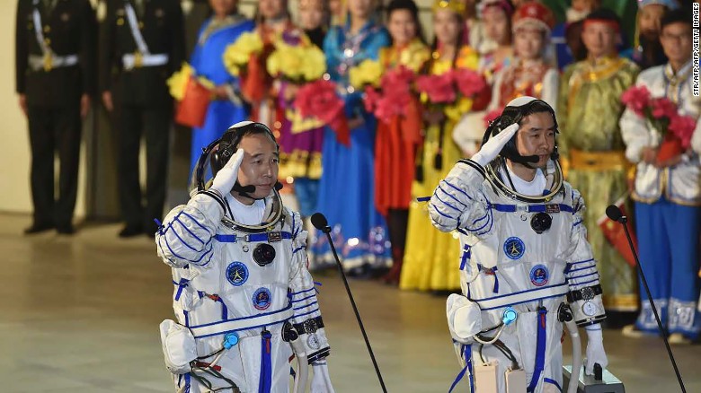 Chinese astronauts Jing Haipeng (L) and Chen Dong salute during the send-off ceremony of the Shenzhou-11 manned space mission at the Jiuquan Satellite Launch Center in Jiuquan, China.