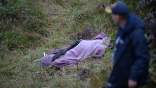 A rescuer walks past the body of a victim from the LaMia Airlines charter plane crash last month. 
