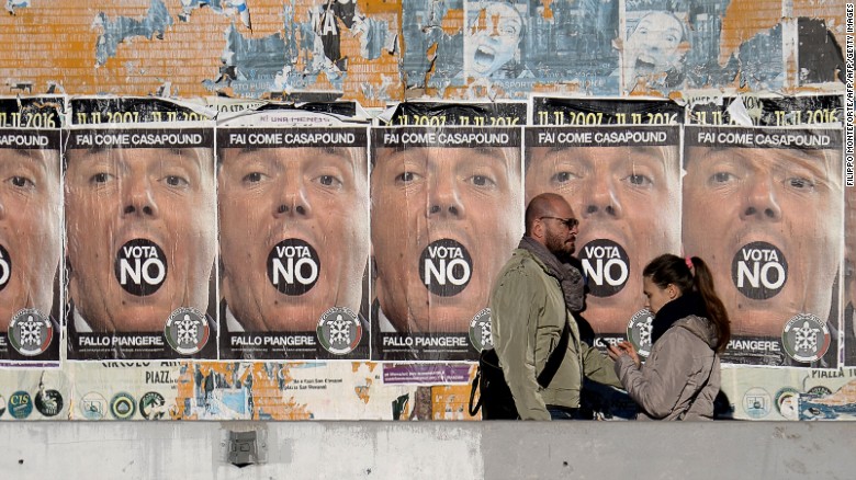 People walk past posters for far-right political movement CasaPound, which is calling for a &quot;No&quot; vote.