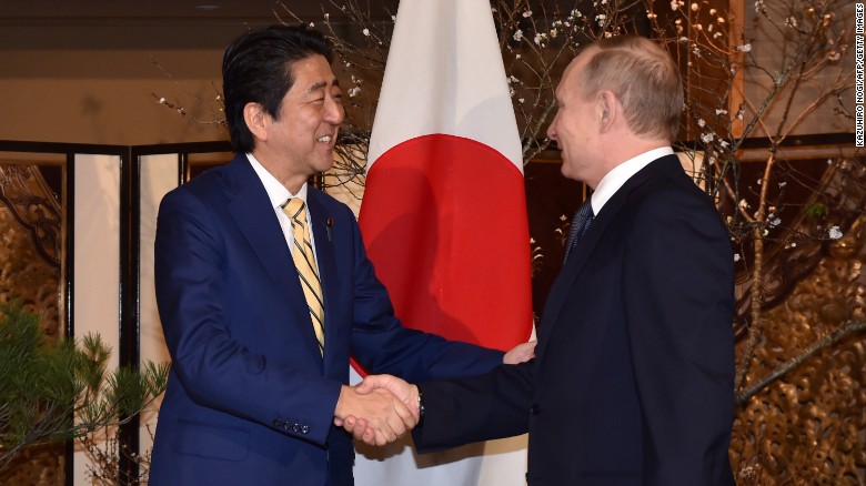 Abe, left, shakes hands with Putin prior to their talks in Nagato on December 15.