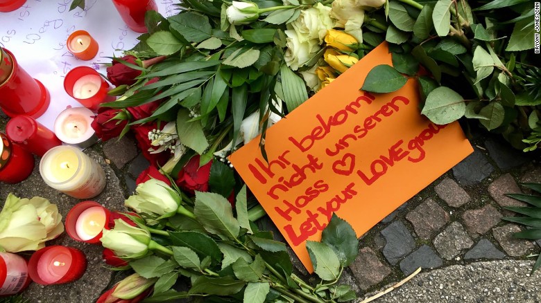 People leave tributes to the Berlin victims. One note reads, &quot;Let your love grow.&quot;