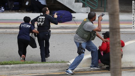Police assist people seeking cover outside Terminal 2 of Fort Lauderdale-Hollywood International airport after a shooting took place near the baggage claim on January 6, in Fort Lauderdale, Florida. 