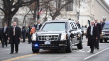Secret Service members surround the presidential limousine as it drives up Pennsylvania Avenue during the Presidential Inaugural Parade on Friday, January 20, in Washington.