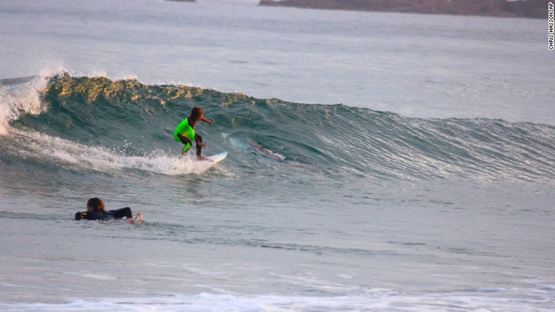 10-year-old Eden Hasson, Chris Hasson&#39;s son, surfs near what is believed to be a great white shark at Samurai Beach, Port Stephens, Australia. James Cook University shark researcher Andrew Chin says the photographed shark is possibly a small great white.