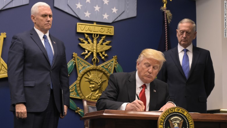 US President Donald Trump signs an executive order alongside US Defense Secretary James Mattis and US Vice President Muike Pence on January 27, 2016 at the Pentagon in Washington, DC. Trump signed an order Friday to begin what he called a &quot;great rebuilding&quot; of the US armed services, promising new aircraft, naval ships and more resources for the military. &quot;Our military strength will be questioned by no one, but neither will our dedication to peace. We do want peace,&quot; Trump said in a ceremony at the Pentagon. / AFP / MANDEL NGAN [Photo credit should read MANDEL NGAN/AFP/Getty Images)