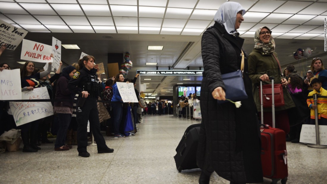 Protesters gather as arriving passengers make their way out of the Washington Dulles International Airport in Dulles, Virginia on Saturday, January 28, 2017, a day after the President Donald Trump signed an executive order announcing a travel ban from seven Muslim-majority nations and temporarily suspending all refugee admission to the US. 