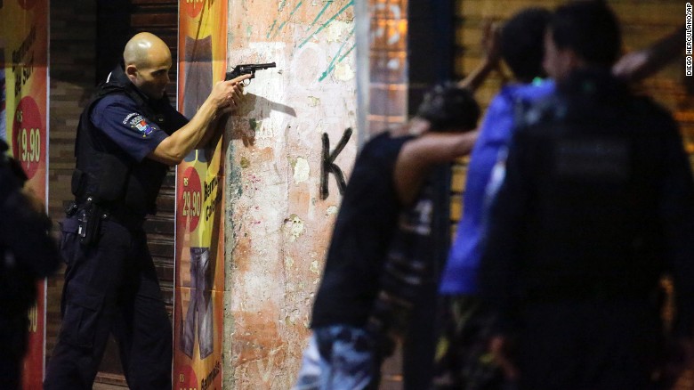 A municipal guard aims his weapon as two men are searched in Vitoria.