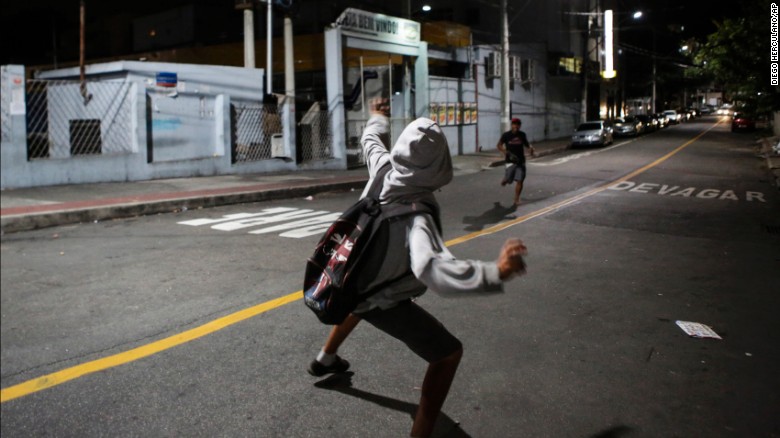 A man prepares to throw a rock at a supermarket.