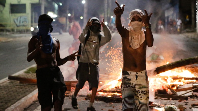 Youths with T-shirts covering their faces gesture next to a barricade in Vitoria on Tuesday.