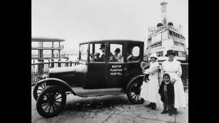 In a historic image, the Floating Hospital ambulance  sits before the hospital ship.