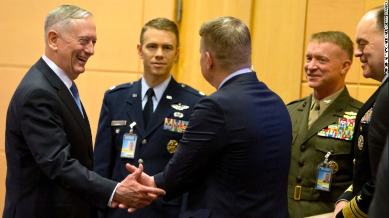 James Mattis (L) speaks with members of his delegation prior to a meeting at NATO headquarters in Brussels.