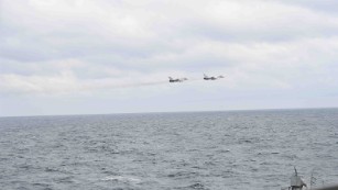 A pair of Russian Su-24s pass within close proximity of the guided-missile destroyer USS Porter while the ship conducts routine maritime operations in international waters.