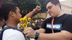 An anti-Duterte protester apologizes with a flower to a Duterte supporter. 