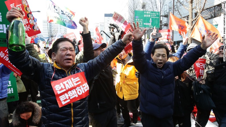 South Koreans celebrate after hearing the Constitutional Court&#39;s verdict.