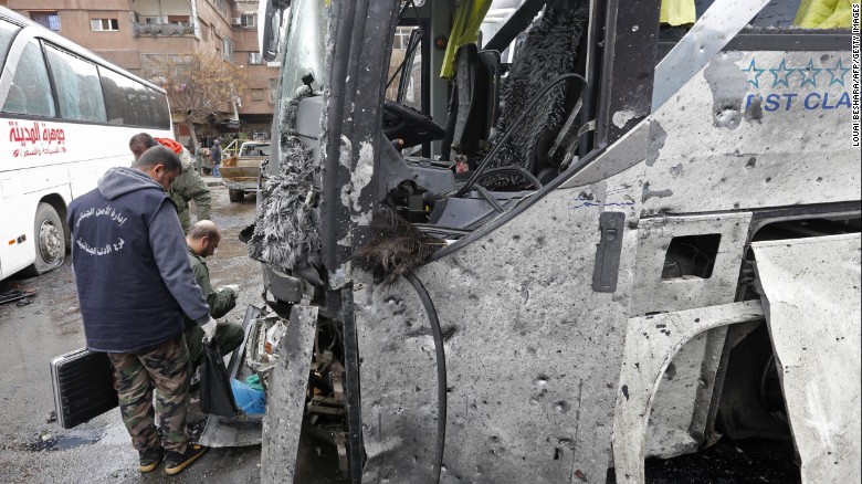 Syrian forensics examine a bus after the blasts.