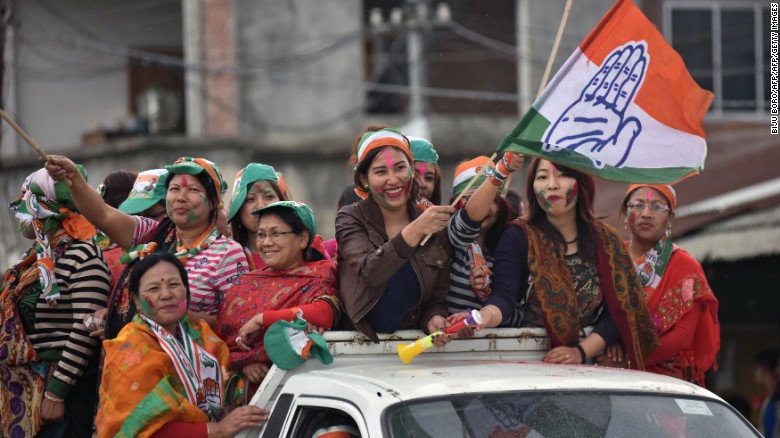 Supporters of India&#39;s Congress wave their flags as they celebrate their candidate&#39;s win in state assembly elections in Imphal on March 11.