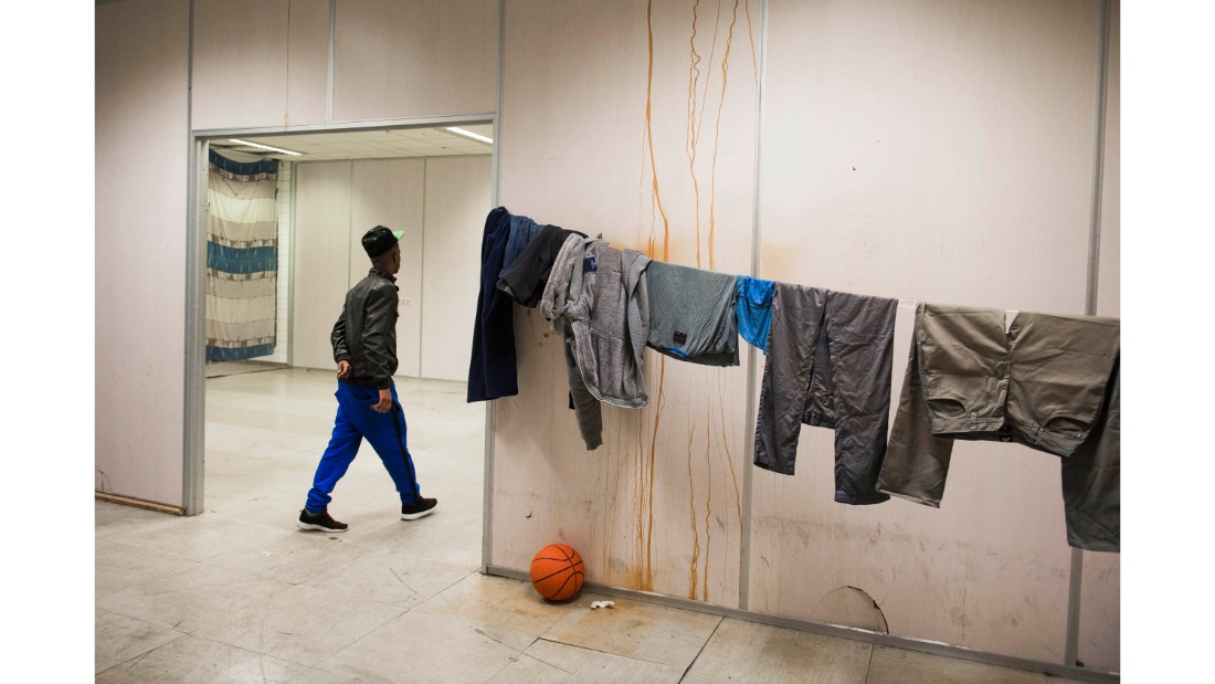 A refugee passes drying laundry at the group&#39;s Vluchttoren location in 2015. Many of the buildings squatted are given a name beginning with &quot;vlucht&quot; meaning &quot;flight,&quot; a moniker for refugees in Dutch.