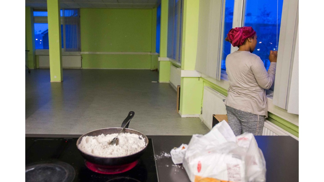 A woman from We Are Here speaks on the phone while cooking at the women&#39;s building in Amsterdam west.