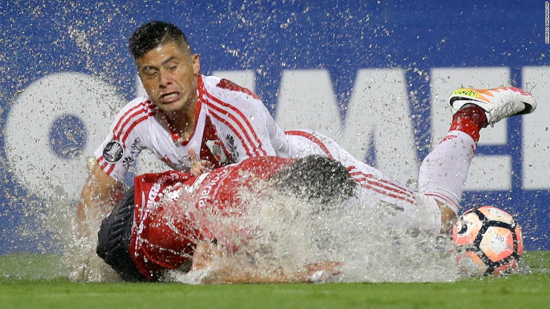 Soccer players splash into the turf Wednesday, March 15, during a rainy Copa Libertadores match in Medellin, Colombia. Argentine club River Plate defeated Independiente 3-1.